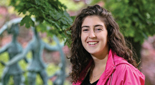 Eliana Padwa, a Brandeis student, stands in front of a sculpture on campus